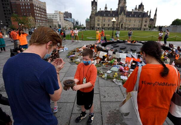June 5, 2021, Ottawa, on, Canada: Joseph Cote-Dent, 7, smudges a participant before a Pipe Ceremony to honour the 215 children whose remains were found at the grounds of the former Kamloops Indian Residential School at Tkâ€⠢emlups te Secwo pemc First Nation in Kamloops, B.C., at the Centennial Flame on Parliament Hill in Ottawa, on Saturday, June 5, 2021. Ottawa Canada - ZUMAc35_ 20210605_zaf_c35_017 Copyright: xJustinxTangx