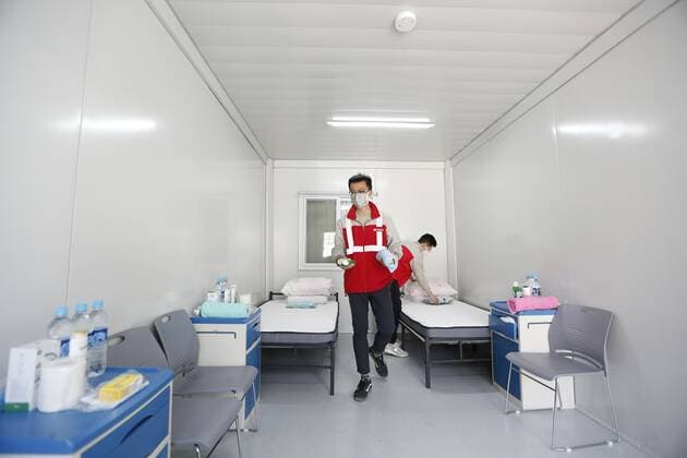 (220302) -- HONG KONG, March 2, 2022 -- Staff members arrange an isolation room for COVID-19 patients at the community isolation facility (CIF) in Tsing Yi, south China s Hong Kong, March 2, 2022. A newly built CIF started admitting its first batch of COVID-19 patients in Hong Kong on Tuesday evening. The facility, located in Tsing Yi, is open for service one day after its construction was completed within just one week on Monday with the support of the mainland. The CIF, with the capacity of accommodating about 3,900 patients, is a combination of modular cubicles, with each room equipped with basic furniture and bedding, air conditioner, smoke detector, and fire extinguisher. ) CHINA-HONG KONG-ISOLATION FACILITY (CN) WanxHoude