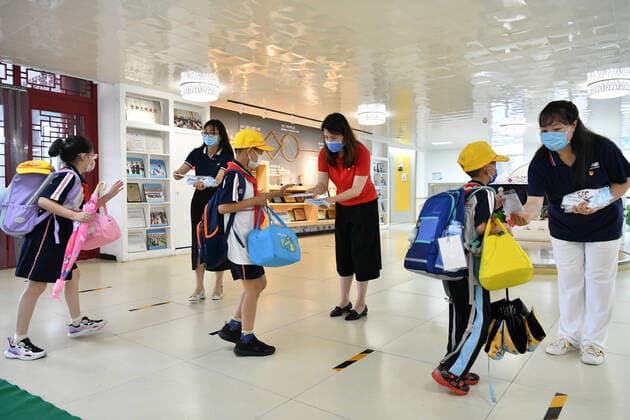 (220627) -- BEIJING, June 27, 2022 -- Faculty members hand masks to students at Yuquan School Attached to Capital Normal University in Beijing, capital of China, June 27, 2022. Beijing s primary and middle school students returned to campus on Monday after over 50 days of remote education due to a local COVID-19 resurgence. Students in the first two years of junior high and senior high schools, or grades 7, 8, 10 and 11, as well as those in primary schools, resumed in-person classes. Education for students in grades 9 and 12 concluded earlier. ) CHINA-BEIJING-SCHOOL REOPENING (CN) LixXin