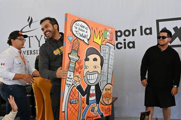 May 22, 2024, Tijuana, Baja California, Mexico: Mexican presidential candidate Jorge Alvarez Maynez of the Citizens Movement party (MC), receives a gift from a supporter, a painting of himself that reads â€oethe new thing has already arrived in Tijuana†during a campaign stop in Tijuana, Baja California, Mexico, where he sought the youth vote at the CETYS University campus on Wednesday, May 22, 2024. Tijuana Mexico - ZUMAm180 20240522_zip_m180_016 Copyright: xCarlosxA.xMorenox