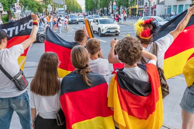 Young soccer fans celebrate the German victory in the match against Hungary, waving German flags on Leopoldstraße, European Football Championship, Munich, June 19, 2024 Germany, Munich, June 19, 2024, soccer fans celebrate the German victory in the match against Hungary, waving German flags on Leopoldstraße,