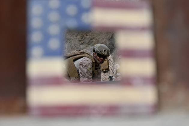 February 6, 2025, Tijuana, Baja California, Mexico: A broken picture frame of the United States flag in captures a member of the US Marine Corps installing concertina wire along the US-Mexico border wall in San Diego, California, seen from Tijuana, Mexico in between the San Diego-Tijuana border fences of Colonia Libertad on Thursday, February 06, 2025. The Defense Department deployed 1,600 active-duty troops to the border during US President Donald Trumpâ€⠢s first week in office. Tijuana Mexico - ZUMAm180 20250206_zip_m180_012 Copyright: xCarlosxA.xMorenox