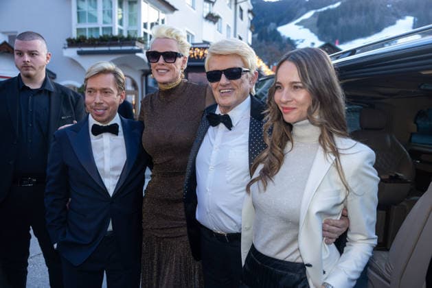 Datum: 13.03.26 Ort: Kitzbühel Im Bild: Helmut Werner, Brigitte Nielsen, Heino, Nicole Werner Er ist Kult blonde Haare, schwarze Sonnenbrille und eine unverwechselbare Jahrhundertstimme: Heino (87) blickt auf eine fast 70-jährige Karriere zurück. Doch nur wenige kennen die Geschichte hinter seiner berühmten dunklen Brille. Der Sänger, der bürgerlich Heinz Georg Kramm heißt, hat in seinem Leben über 55 Millionen Tonträger verkauft. Ob Schlager, Pop, Heavy Metal, Ballermann, Rap oder Klassik kaum ein Genre blieb ihm fremd. Bis heute steht der Kultstar auf der Bühne: Er tritt bei großen Festivals wie dem Parookaville vor Zehntausenden Fans genauso selbstverständlich auf wie bei klassischen Kirchenkonzerten, etwa in der xchristian esslerx