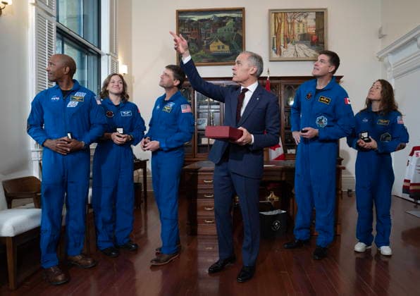 May 13, 2026, Ottawa, On, Canada: Prime Minister Mark Carney gestures to the Peace tower before presenting Artemis II mission pilot Victor Glover, left to right, astronaut Jenni Gibbons, Commander Reid Wiseman, astronaut Jeremy Hansen and mission specialist Christina Koch with a flag which flew on the day they returned to earth, during an event in his office in Ottawa on Wednesday, May 13, 2026. Ottawa Canada - ZUMAc35_ 20260513_zaf_c35_006 Copyright: xAdrianxWyldx