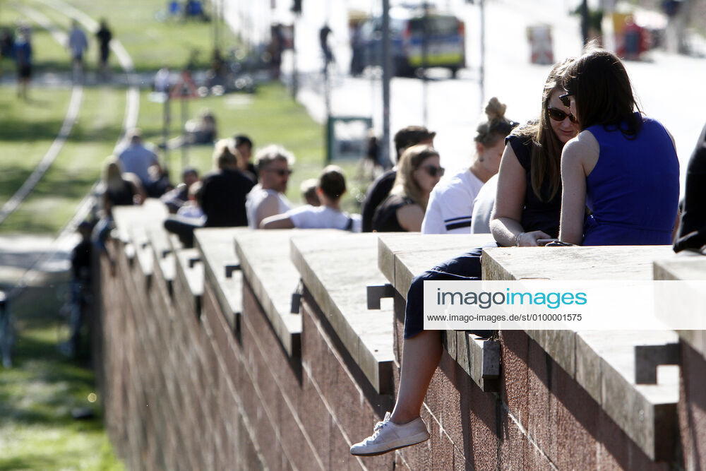 Despite the coronavirus crisis, curfews and contact bans, large numbers of sun-seekers enjoy the warm temperatures and sunshine on the steps of a bridge over the Main in downtown Frankfurt and do not always keep the minimum distance.