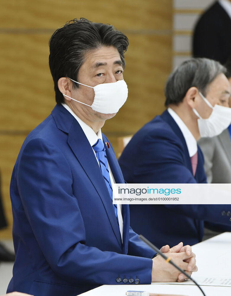 New coronavirus Japanese Prime Minister Shinzo Abe (L) attends a meeting of the government task force on combatting the new coronavirus pandemic in Tokyo on April 27, 2020.