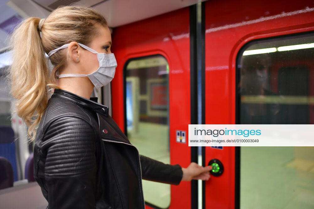 Woman with a face mask, standing in a train, opens doors, corona crisis, Stuttgart, Baden Württemberg, Germany Coronavirus