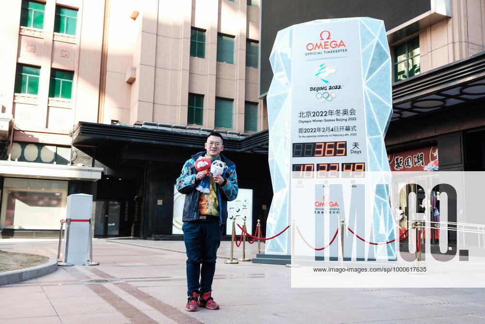 A man holding mascot of Beijing 2022 Olympic Winter games, Winterspiele,Spiele, Summer games Bing Dwen Dwen and mascot of Beijing 2022 Paralympic Winter Games Shuey Rhon Rhon poses for a photo in front of a countdown clock for the Beijing 2022 Olympic Winter Games at the Wangfujing Street on February 4, 2021 in Beijing, China. China on Thursday marks the one-year countdown to the 2022 Winter Olympics, which will open on February 4 next year.