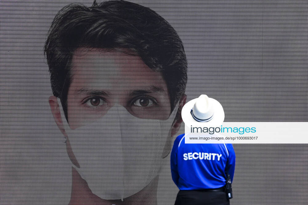 TENNIS AUSTRALIAN OPEN, A security guard stands next to a large display showing a man wearing a face mask on Day 1 of the Australian Open at Melbourne Park in Melbourne, Monday, February 8, 2021. ( NO ARCHIVING, , NO USE IN BOOKS WITHOUT CONSENT MELBOURNE VIC AUSTRALIA
