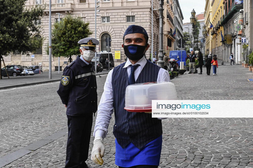 Bartender is on his way to deliver coffee in Naples, after the lockdown due to Government Decree declaring all of Italy a protected area to combat Covid-19 - Coronavirus infection. A new Government Decree has established rules for gradually reopening economic and social activities from today.