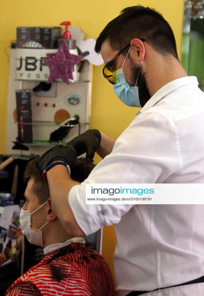 Belgrade(Serbia) Coronavirus Covid-19 Life loosening measures Friseur hairdresser studio Goca Gotza open after 43 days state of emergency.Friseour hairdresser Nikola working with protection mask,gloves and glasses.