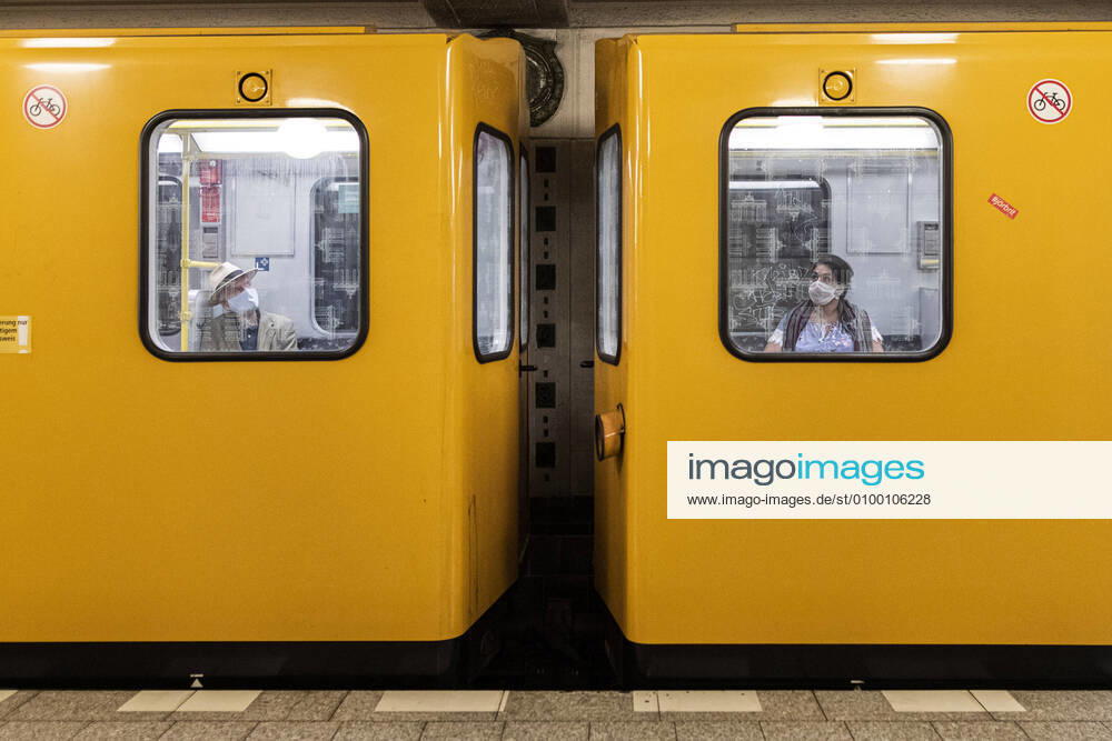 Two people with mouth-nose masks are sitting in different cars of the underground in Berlin, 28 04 2020 Throughout Germany there is a mask obligation in public transport Berlin Germany