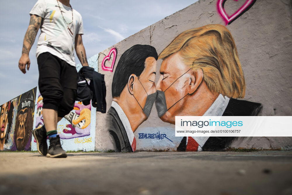 A graffiti shows Donald Trump, President of the United States of America, and President of the Peoples Republic of China Xi Jinping, kissing with a face mask in Berlin, 28 04 2020 Berlin Germany