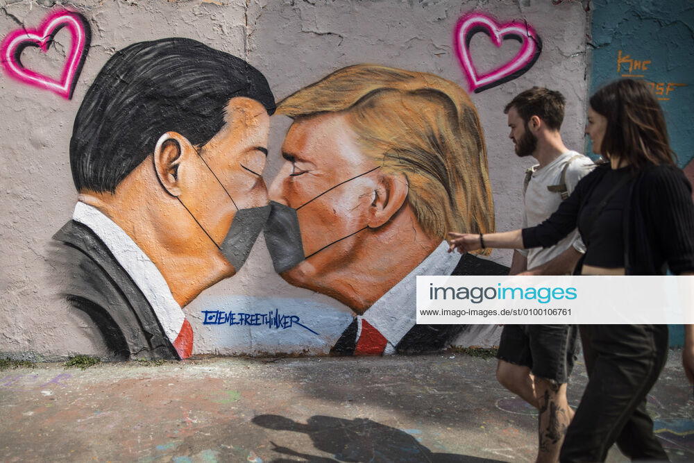 A graffiti shows Donald Trump, President of the United States of America, and President of the Peoples Republic of China Xi Jinping, kissing with a face mask in Berlin, 28 04 2020 Berlin Germany