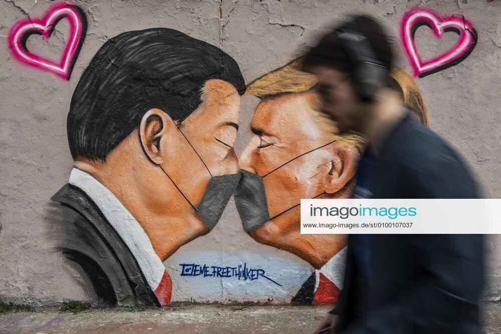 A graffiti shows Donald Trump, President of the United States of America, and President of the Peoples Republic of China Xi Jinping, kissing with a face mask in Berlin, 28 04 2020 Berlin Germany