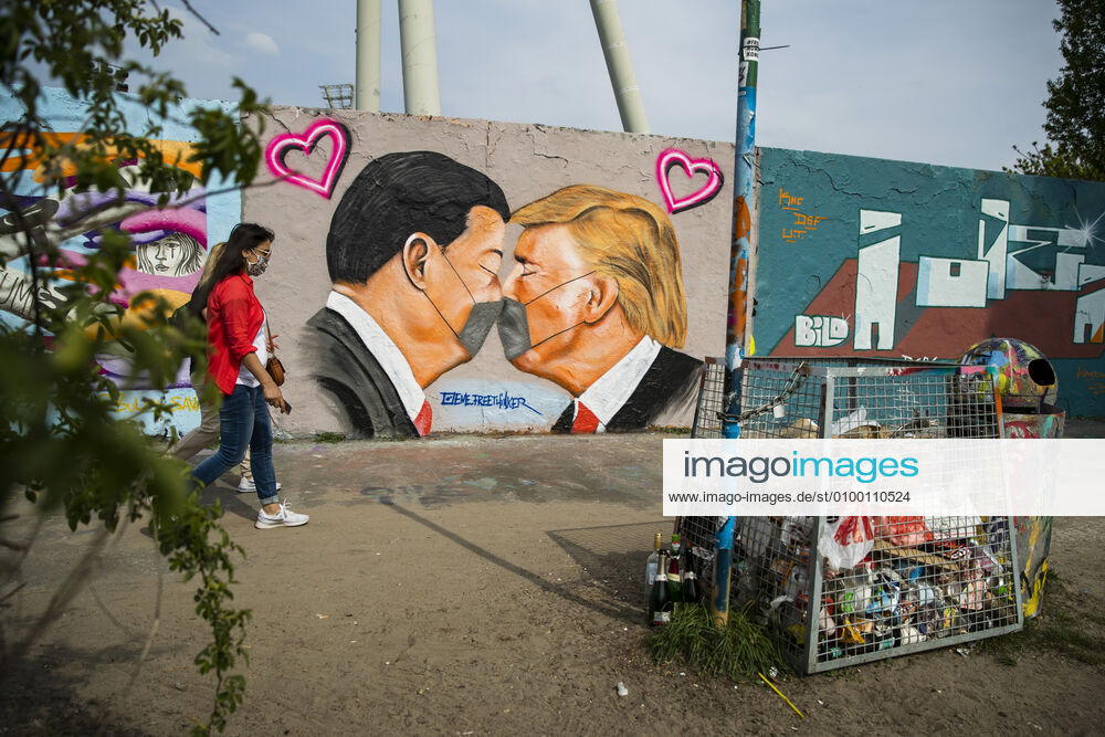 Graffiti by artist Eme Freethinker with USA President Donald Trump and Chinese President Xi Jinping kissing each other with a face mask at Mauerpark in Berlin on April 28, 2020 Since yesterday, it is mandatory to wear nose and mouth protection on trains, trams and busses Starting tomorrow, it will also be mandatory for retailers Coronavirus in Berlin