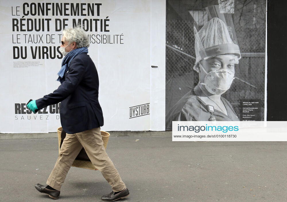 A passer-by wears a mask as he walks past a Covid-19 poster in the streets of Paris, France, Tuesday April 28, 2020. The French premier announced today that protective masks, which have been in severe shortage since the outbreak of the pandemic, will be available for everyone starting May 11th. PAR20200428101 ECOxCLEMENT