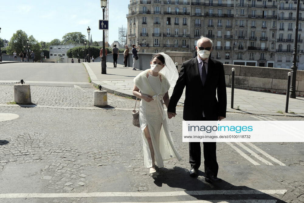 A couple celebrating their wedding anniversary wear masks as they take a stroll in the near empty streets of Paris, France, Tuesday April 28, 2020. The French premier announced today that protective masks, which have been in severe shortage since the outbreak of the pandemic, will be available for everyone starting May 11th. PAR20200428105 ECOxCLEMENT