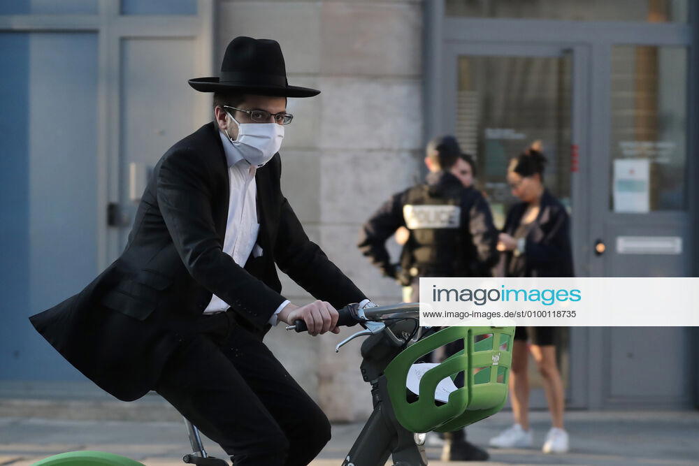 A masked biker rides past security forces checking on residents permit to be in the streets of Paris, France, Tuesday April 28, 2020 as the country enters its 6th week of confinement. The French premier announced today that protective masks, which have been in severe shortage since the outbreak of the pandemic, will be available for everyone starting May 11th. PAR20200428108 ECOxCLEMENT