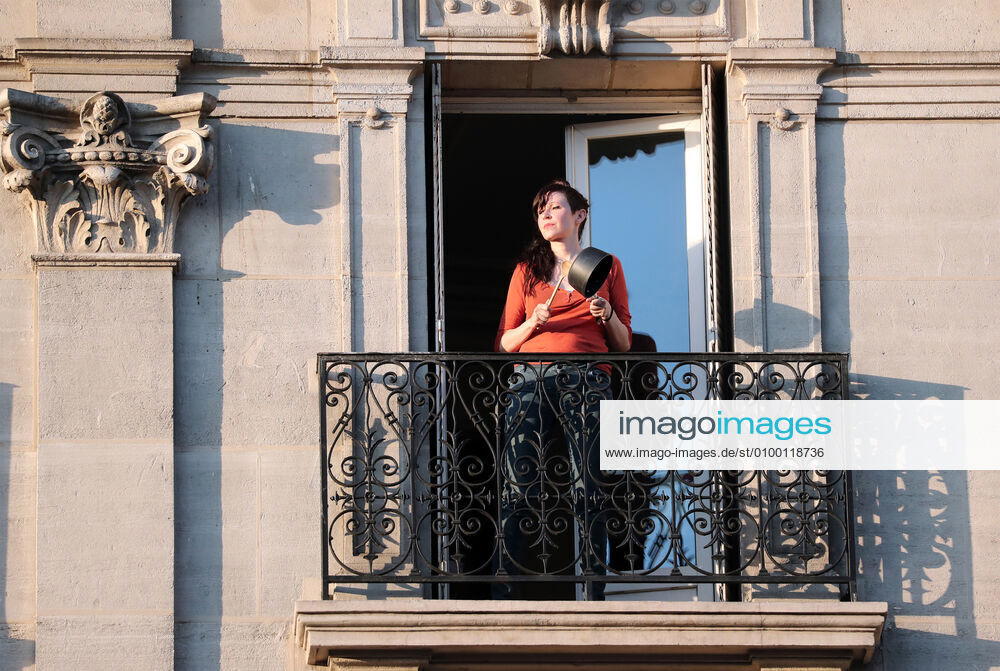 A resident bangs a cooking pan with a wooden spoon from her balcony to make noise for health workers in Paris, France, Tuesday April 28, 2020 as country enters its 6th week of confinement. The French premier announced today that protective masks, which have been in severe shortage since the outbreak of the pandemic, will be available for everyone starting May 11th. PAR20200428109 ECOxCLEMENT