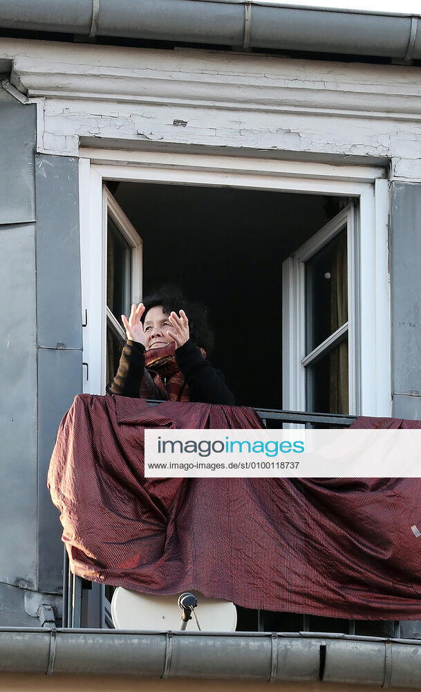A resident applauds health workers from her balcony in Paris, France, Tuesday April 28, 2020 as country enters its 6th week of confinement. The French premier announced today that protective masks, which have been in severe shortage since the outbreak of the pandemic, will be available for everyone starting May 11th. PAR20200428110 ECOxCLEMENT