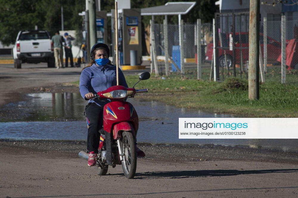 Coronavirus, Eindrücke aus Argentinien April 28, 2020, Firmat, Santa Fe, Argentina: A woman wearing a blue face mask rides a scooter. The daily life of a little country town has seen a big change due to the COVID-19 outbreak. Despite only one positive case to date in the city, the use of face masks is mandatory in all public spaces to prevent the spread of the coronavirus. Firmat Argentina - ZUMAm105 20200428_zaf_m105_009