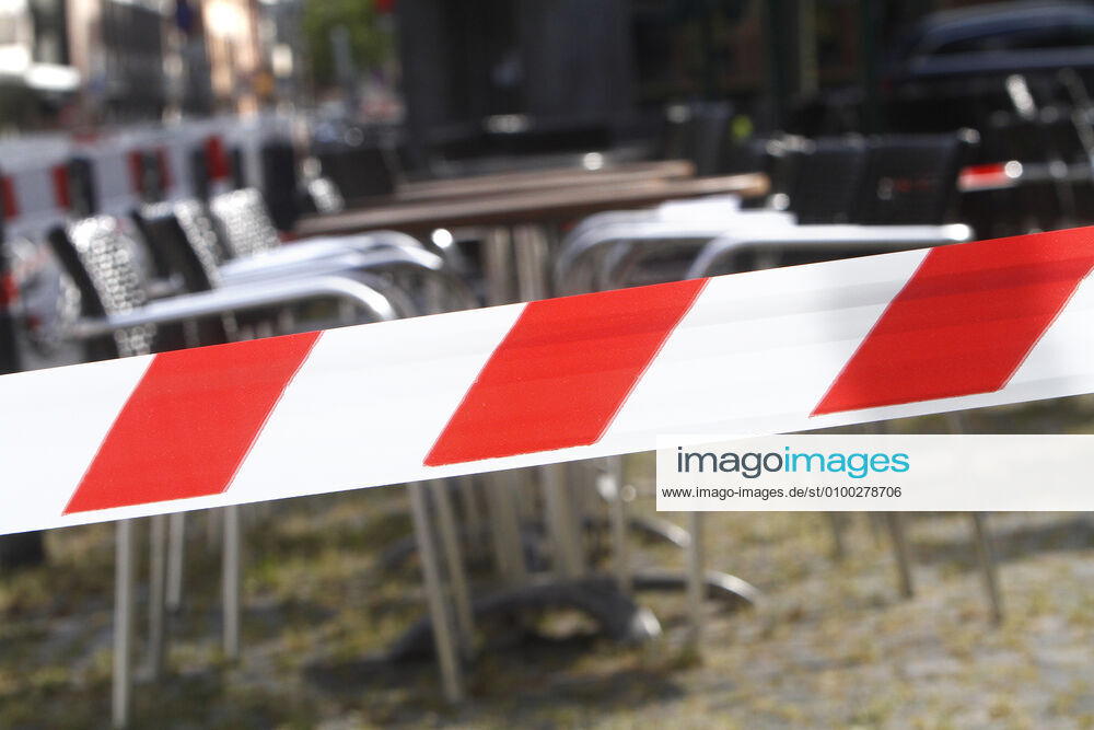 Barrier tape around tables and chairs of a closed restaurant in the city centre of Mannheim, Baden Württemberg, Germany