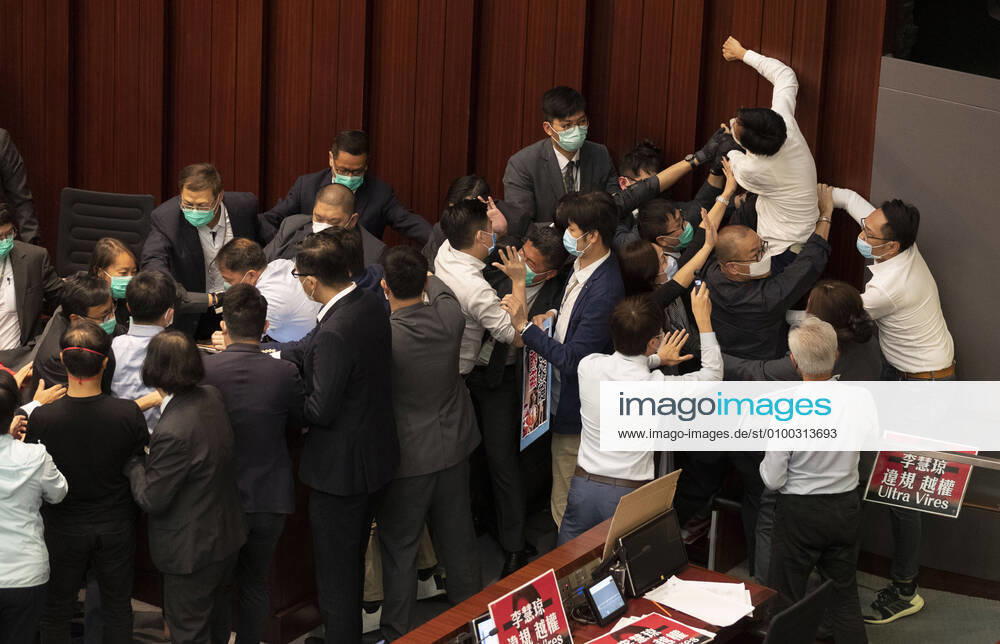 Pro-democracy lawmaker Eddie Chu Hoi-dick (R, wearing white) trying to climb a wall in protest as security try to restrain him after pro-Beijing lawmaker Starry Lee (not seen) sat in the chairpersons seat before a key committee meeting at the Legislative Council in Hong Kong, China, 08 May 2020. Pro-democracy and the pro-Beijing camps scuffled for control of the House Committee which has been gridlocked for months. The House Committee is responsible for scrutinising bills before sending them for a final vote. Hong Kong China - ZUMAj323 20200508_zip_j323_003