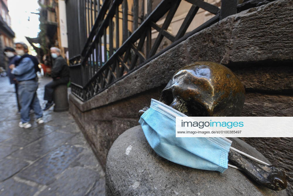 A protective mask is placed on a statue of a skull, in Naples city. Government Decree declaring all of Italy a protected area to combat Covid-19 - Coronavirus infection.