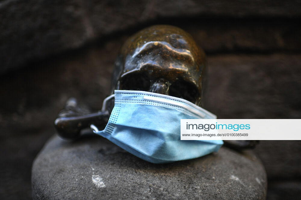 A protective mask is placed on a statue of a skull, in Naples city. Government Decree declaring all of Italy a protected area to combat Covid-19 - Coronavirus infection.