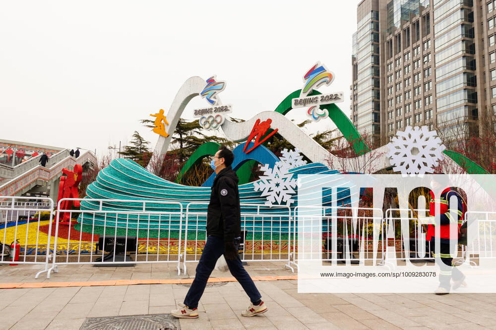 China Olympics 2022 Preparations 6746094 21.01.2022 Men wearing protective face masks walk past a decoration installed for the upcoming 2022 Winter Olympics, in Beijing, China. Anna Ratkoglo Sputnik Beijing China