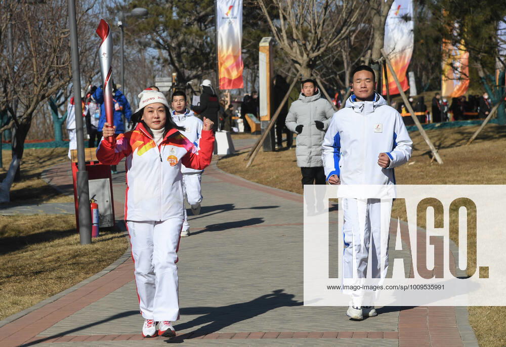 (220204) -- BEIJING, Feb. 4, 2022 -- Torch bearer Wang Caihong (L) runs with the torch during the Beijing 2022 Olympic Torch Relay at the Grand Canal Forest Park in Tongzhou District of Beijing, capital of China, Feb. 4, 2022. ) (BEIJING2022)CHINA-BEIJING-OLYMPIC TORCH RELAY (CN) RenxChao