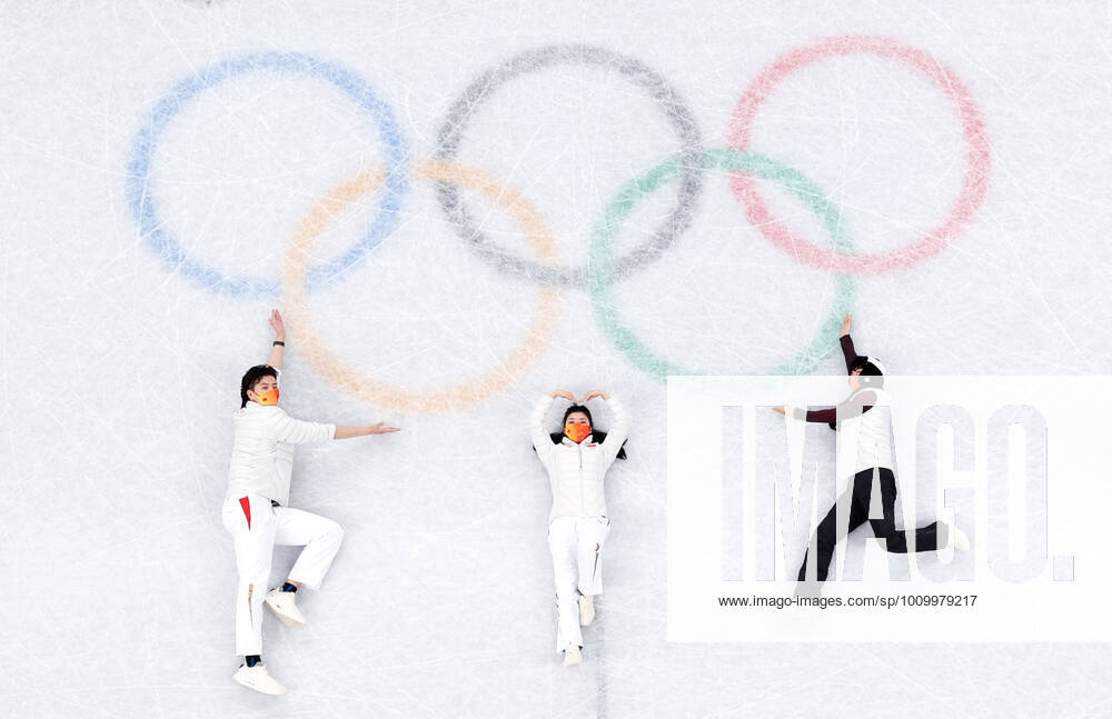 (220219) -- BEIJING, Feb. 19, 2022 -- China s Ice dancing, Eistanzen pair of Liu Xinyu and Wang Shiyue, Chinese figure skater Jin Boyang (L to R) lie on the ice rink to pose for a photo with the Olympic Rings in the background after the Figure skating, Eiskunstlauf pair skating free skating of the Beijing 2022 Winter Olympics at Capital Indoor Stadium in Beijing, capital of China, Feb. 19, 2022. ) (BEIJING2022)CHINA-BEIJING-OLYMPIC Winter games, Winterspiele,Spiele, Summer games FIGURE SKATING-PAIR SKATING-FREE SKATING (CN) MaxNing