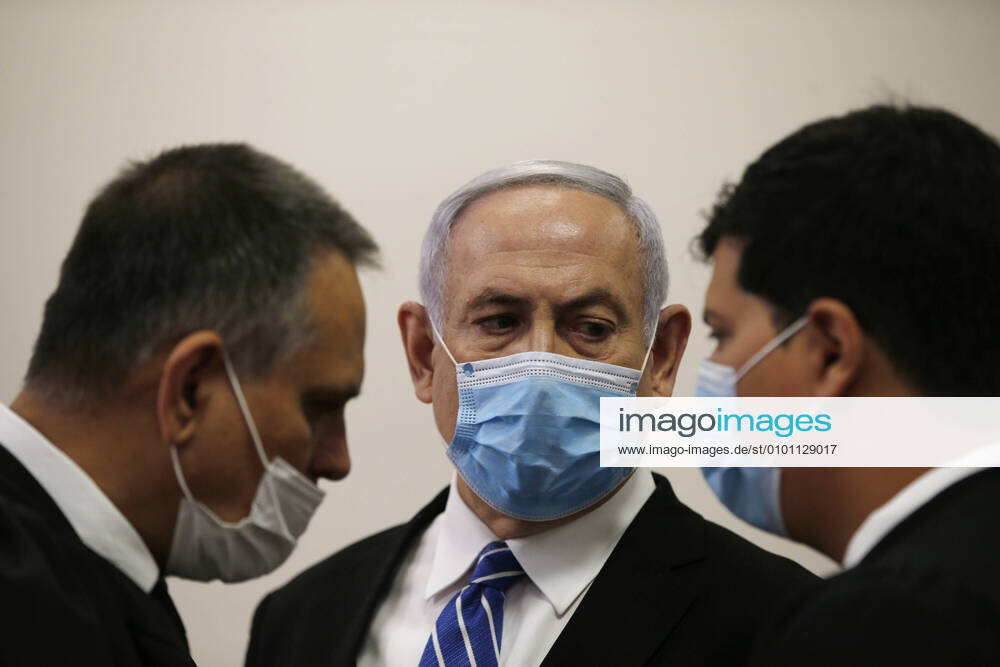 Israeli Prime Minister Benjamin Netanyahu, wearing a face mask, looks at his lawyer while standing inside the court room as his corruption trial opens at the Jerusalem District Court on Sunday, May 24, 2020. Netanyahu attacked the Israeli justice system as he became the first sitting prime minister to go on trial. Pool JERZ2020052402 RONENxZVULUN
