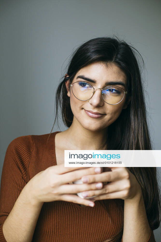 Thoughtful young businesswoman having coffee during break in office model released Symbolfoto property released ABZF03089