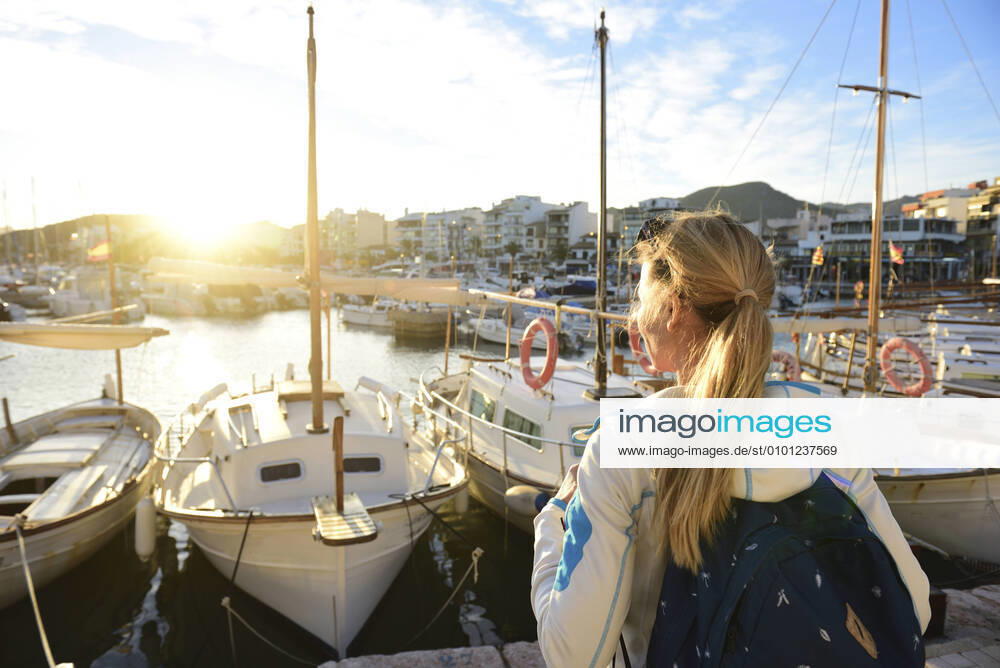 Woman enjoying sunset at harbour, Port de Pollenca, Mallorca, Spain model released Symbolfoto ECPF00896