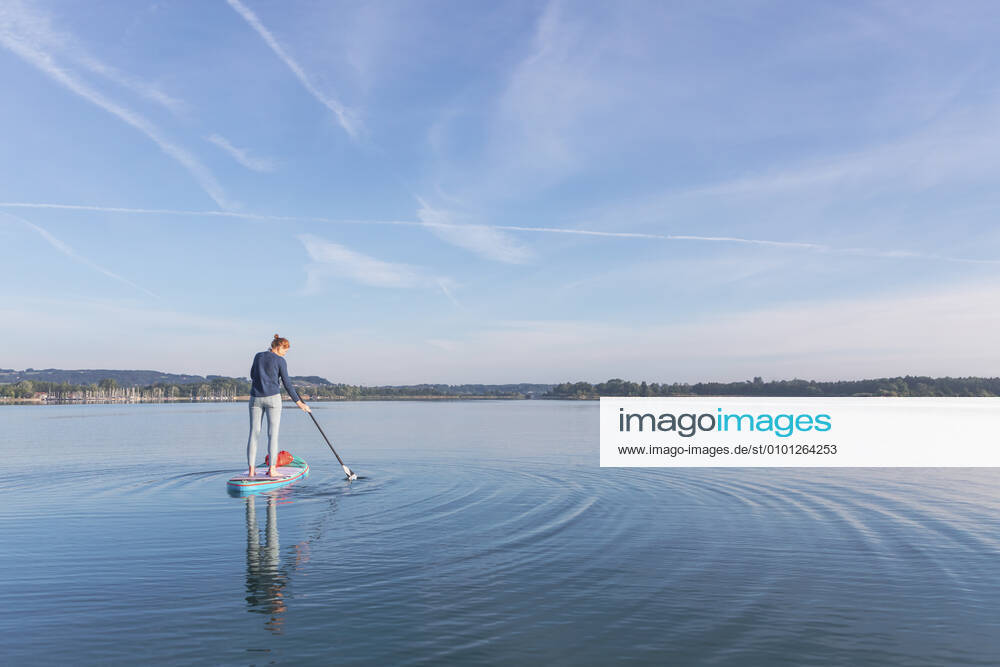 Woman standing on sup board in the morning on a lake, Germany model released Symbolfoto MMAF01302