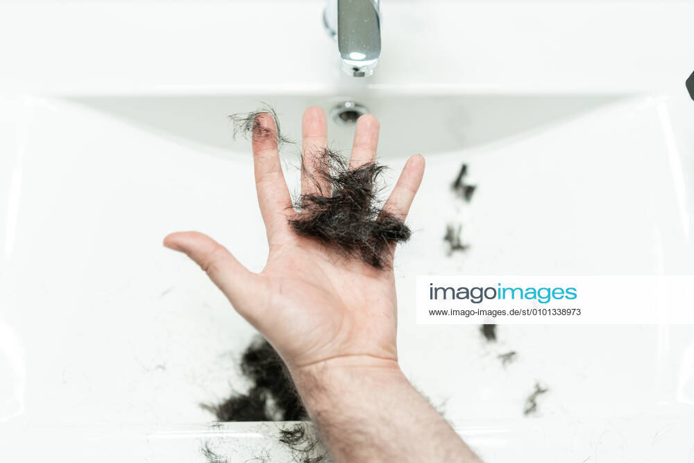 Self haircut. An anonymous man holds strands of hair in the bathroom with his hand Madrid, Community of Madrid, Spain CR_ALSA200429B-372735-01,model released, Symbolfoto