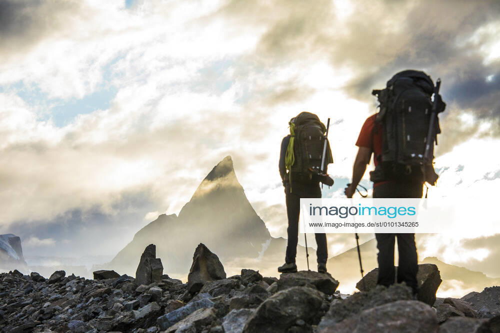 Rear view of backpackers approaching dramatic mountain summit, Canada. Pangnirtung, NU, Canada CR_JDIP200518-319434-01,model released, Symbolfoto