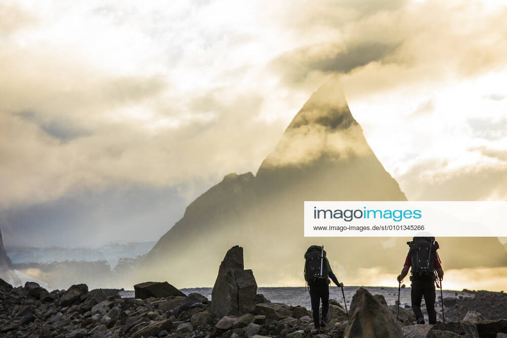 Rear view of backpackers approaching dramatic mountain, Mt. Loki Pangnirtung, NU, Canada CR_JDIP200518-319442-01,model released, Symbolfoto