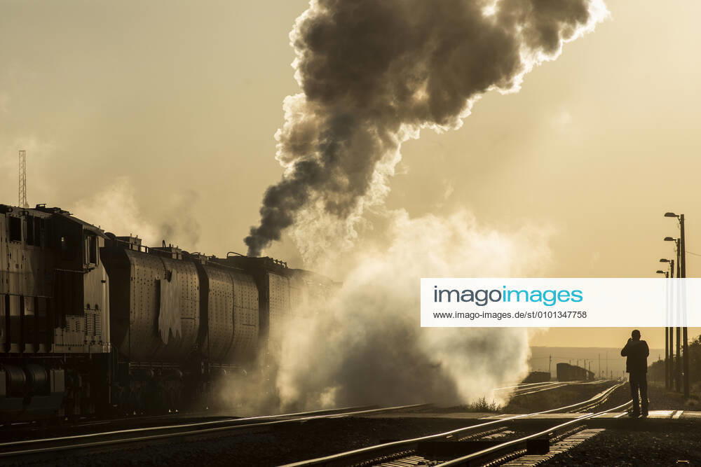 Steam engine smoking heavily moves down track into yellow sunrise Lordsburg, NM, United States CR_MALI200508-354443-01,