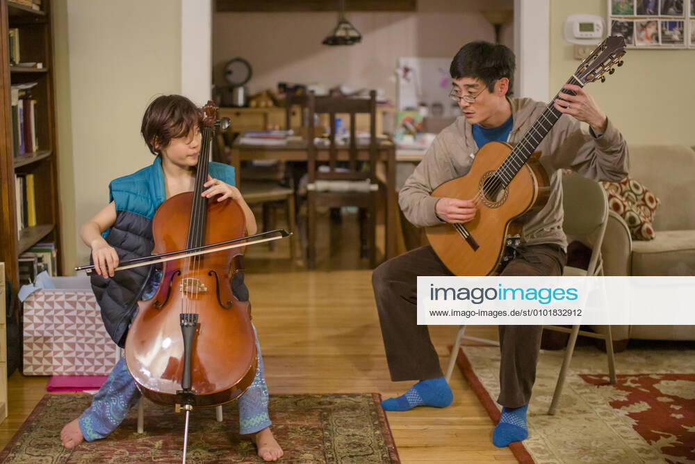 IMAGO Creative: Bildung, Musikerziehung a tween boy and his father play music together in living room at home Columbus, OH, United States CR_RETI200601A-359929-01 ,model released, Symbolfoto