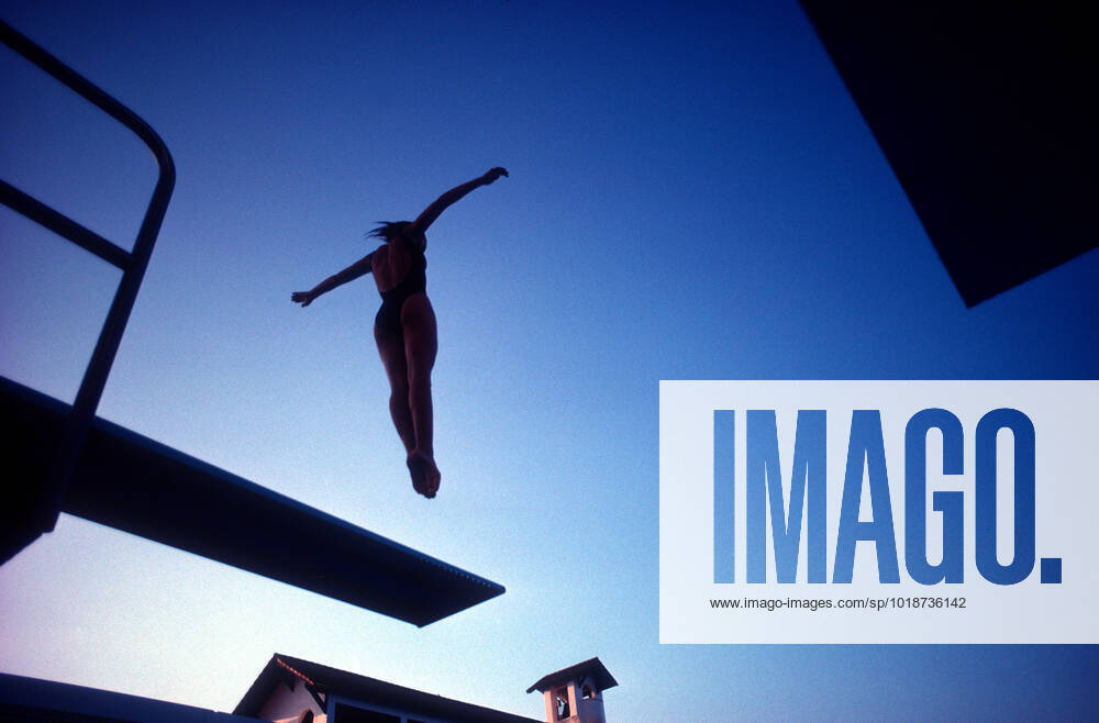 A young diver practicing off the one meter board in Ft. Lauderdale, Florida Silouhette of competitive diver practicing against blue sky
