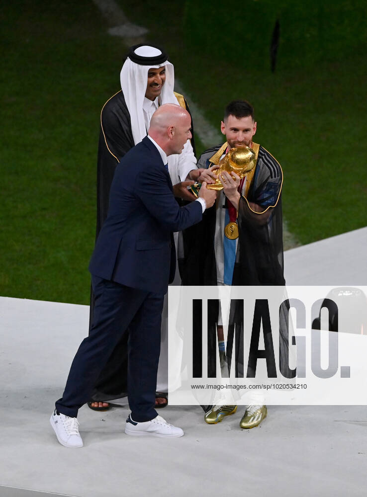 FOOTBALL World Cup 2022 Final Argentina France 18 12 2022 Lionel Messi in cape Bischt receives the World Cup trophy from Tamim bin Hamad Al Thani Emir of Qatar and Fifa President Gianni Infantino