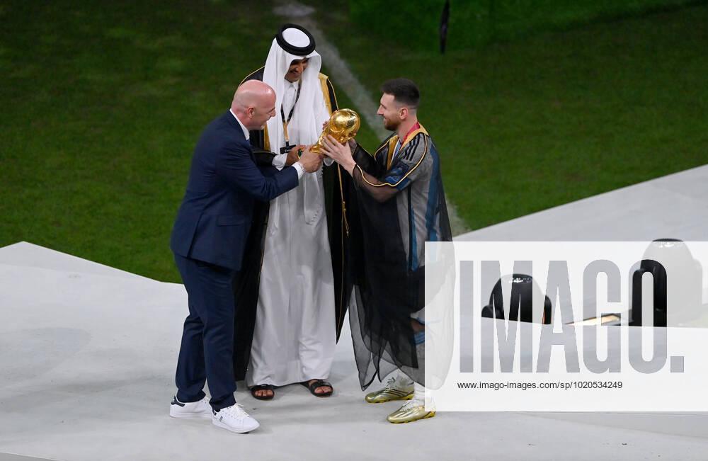 FOOTBALL World Cup 2022 Final Argentina France 18 12 2022 Lionel Messi in cape Bischt receives the World Cup trophy from Tamim bin Hamad Al Thani Emir of Qatar and Fifa President Gianni Infantino