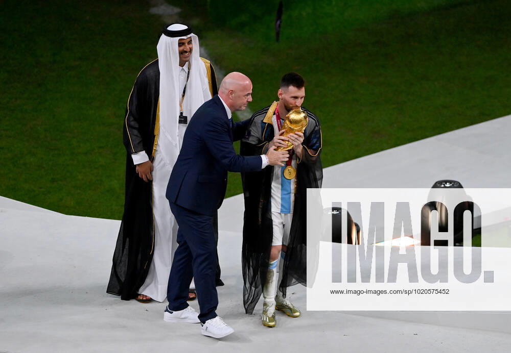 FOOTBALL World Cup 2022 Final Argentina France 18 12 2022 Lionel Messi in cape Bischt receives the World Cup trophy from Tamim bin Hamad Al Thani Emir of Qatar and Fifa President Gianni Infantino