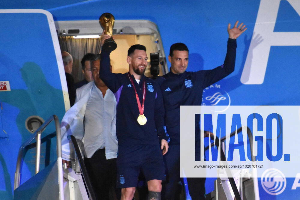 KW51 (221221) -- BUENOS AIRES, Dec. 21, 2022 -- Argentina s Lionel Messi (L) holds the FIFA World Cup, WM, Weltmeisterschaft, Fussball trophy alongside head coach Lionel Scaloni upon arrival at Ezeiza International Airport after the team winning the Final of the 2022 FIFA World Cup in Buenos Aires, capital of Argentina, Dec. 20, 2022. (TELAM Handout via Xinhua) (SP)ARGENTINA-BUENOS AIRES-FOOTBALL-2022 WORLD CUP-TEAM ARGENTINA-ARRIVAL MeixZhoutongxunshe