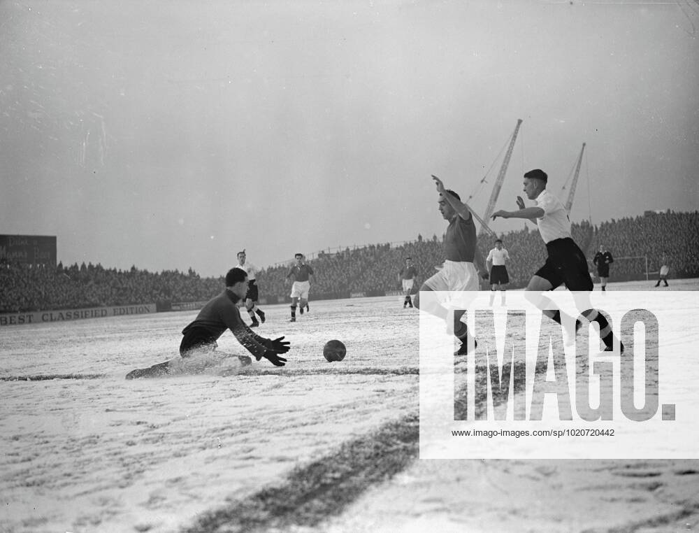 FOOTBALL STUDY- IN BLACK AND WHITE Sliding to his knees in the snow , Ian BLACK , Fulham s goalkeeper , shoots out ready hands to take the ball from the rushing Manchester United, ManU centre-forward John ASTON in the First Division match at Craven Cottage ground , London . Aston England international full-back , was playing at centre forward in the absence of Rowley, helped his team to a 2-2 draw against Fulham . 16 December 1950 United Kingdom England
