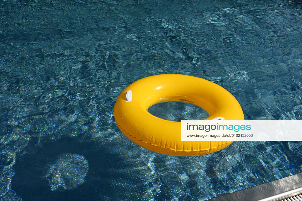 Symbolic image of an open-air swimming pool a yellow swimming tire floating on the surface of a swimming pool, Löffingen, Baden Württemberg, Germany