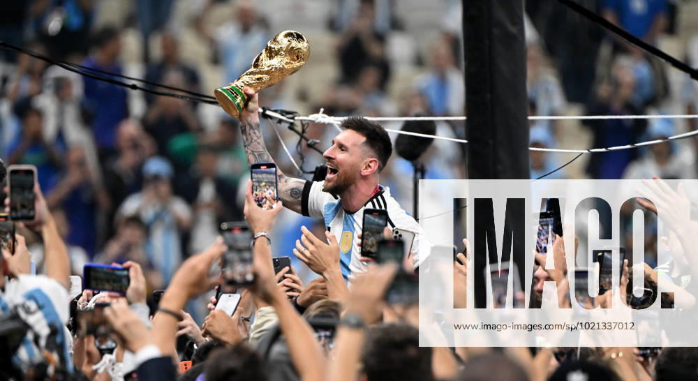 Football, men, season 2022 23, World Cup in Qatar, final, Argentina France 2 2, 3 3 n V, 4 2 i E at Lusail Iconic Stadium in Lusail, Lionel Messi Argentina with trophy, he is carried on shoulders long after the end of the game in the area behind the goal, he is photographed and filmed by fans with cell phones, cheering after the final whistle, 18 12 2022,